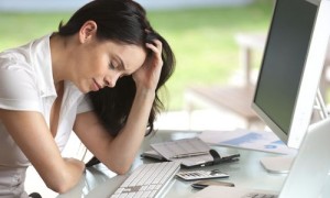 Woman looking stressed at her desk